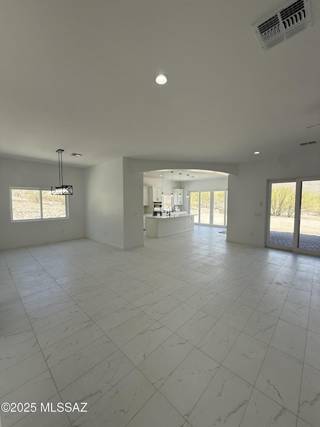 empty room with visible vents, recessed lighting, a chandelier, and marble finish floor