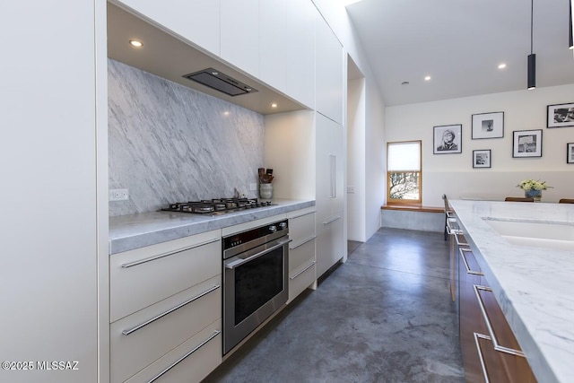 kitchen featuring appliances with stainless steel finishes, backsplash, finished concrete floors, white cabinetry, and modern cabinets