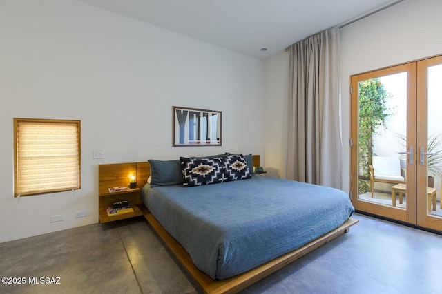 bedroom featuring access to outside, french doors, and finished concrete floors