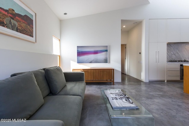 living area featuring recessed lighting, finished concrete flooring, and lofted ceiling