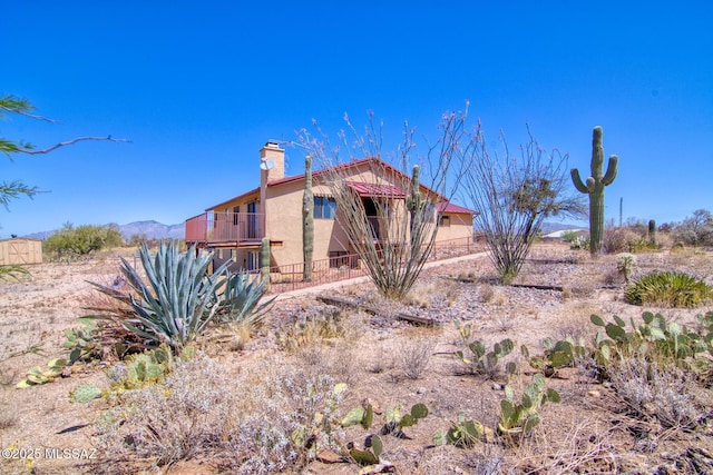4050 S Melpomene Way, Tucson, AZ 85730 - rear view of property with stucco siding, a balcony, and a chimney