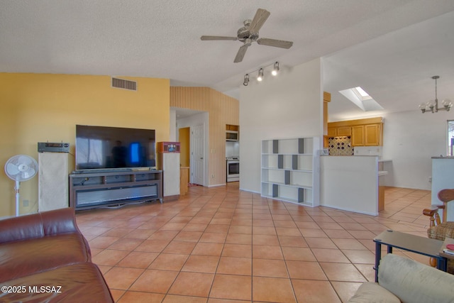 4050 S Melpomene Way, Tucson, AZ 85730 - living room with vaulted ceiling with skylight, a textured ceiling, ceiling fan with notable chandelier, light tile patterned floors, and visible vents