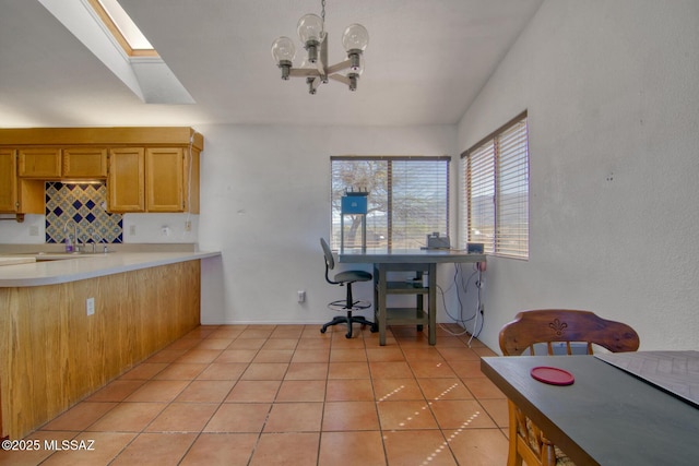 4050 S Melpomene Way, Tucson, AZ 85730 - kitchen featuring light tile patterned floors, light countertops, a skylight, and a chandelier