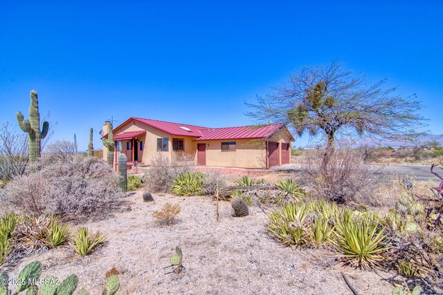 4050 S Melpomene Way, Tucson, AZ 85730 - single story home with stucco siding, a chimney, and metal roof