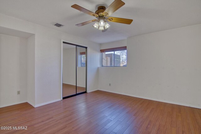 4050 S Melpomene Way, Tucson, AZ 85730 - unfurnished bedroom featuring ceiling fan, visible vents, wood finished floors, baseboards, and a closet