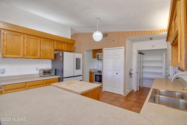 4050 S Melpomene Way, Tucson, AZ 85730 - kitchen featuring visible vents, freestanding refrigerator, light countertops, a sink, and stainless steel range with electric cooktop