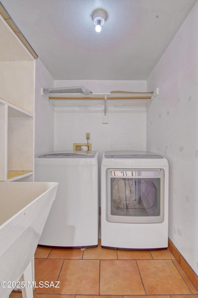 4050 S Melpomene Way, Tucson, AZ 85730 - laundry area with laundry area, a textured ceiling, washing machine and clothes dryer, a sink, and baseboards