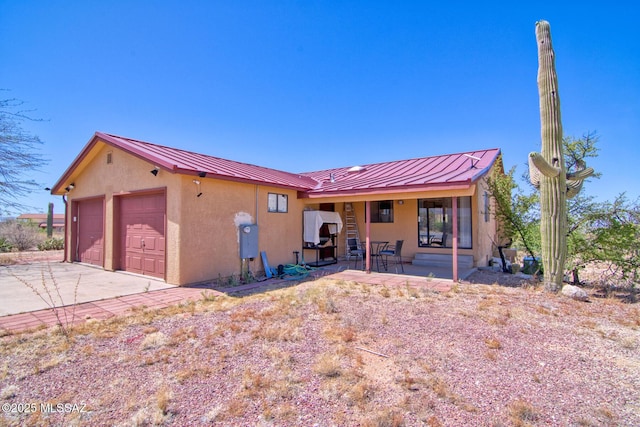 4050 S Melpomene Way, Tucson, AZ 85730 - view of front facade featuring a standing seam roof, covered porch, stucco siding, and metal roof