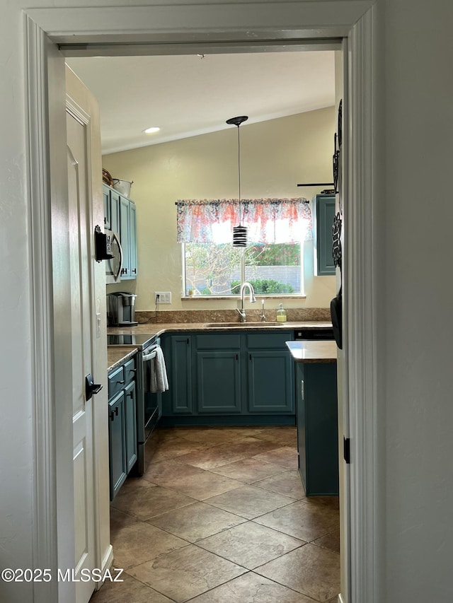 kitchen featuring a sink, stone finish floor, pendant lighting, and stainless steel range with electric stovetop