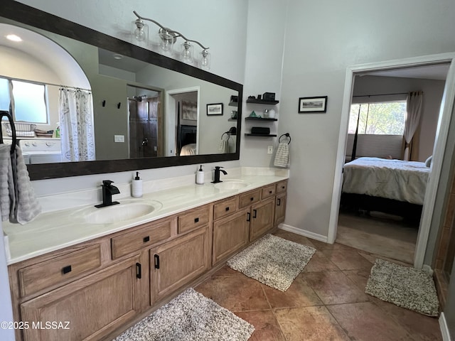 ensuite bathroom with double vanity, a stall shower, a sink, and ensuite bath