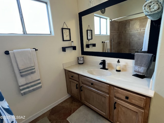 full bathroom with vanity, baseboards, tile patterned floors, and a tile shower