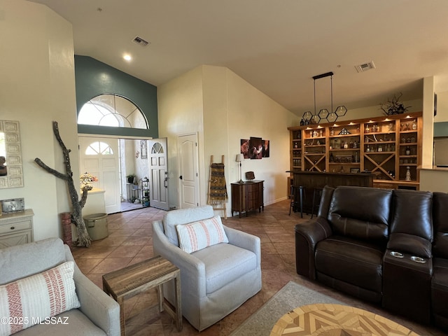 living area featuring high vaulted ceiling, tile patterned floors, and visible vents