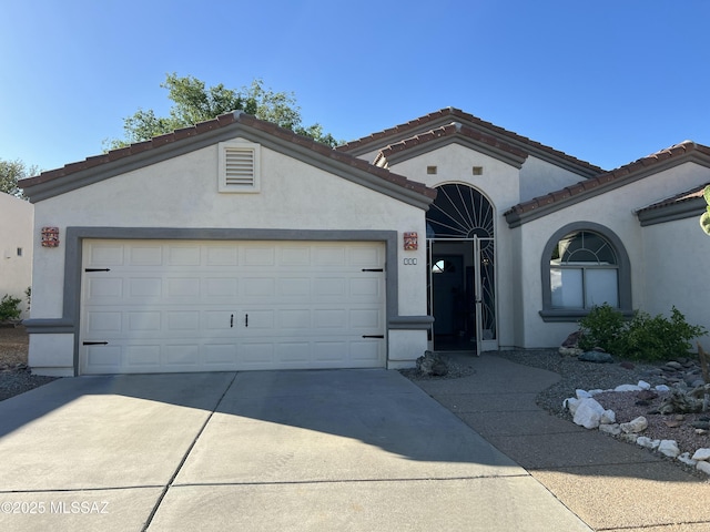 mediterranean / spanish-style house with concrete driveway, an attached garage, and stucco siding