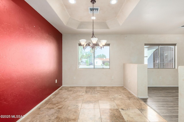 spare room featuring visible vents, baseboards, a raised ceiling, a notable chandelier, and recessed lighting