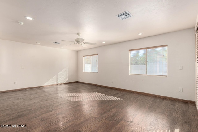 unfurnished room with baseboards, visible vents, and wood finished floors