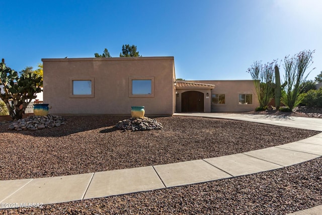 pueblo revival-style home featuring stucco siding