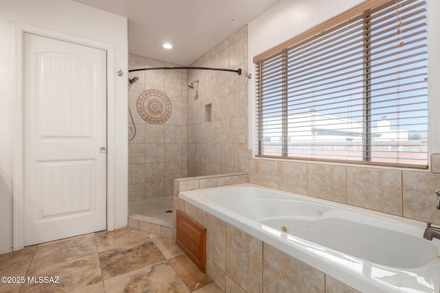 bathroom with tiled shower and a bath