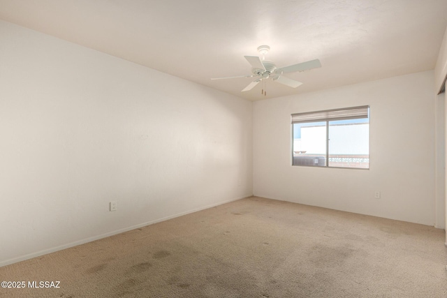 spare room with ceiling fan and carpet