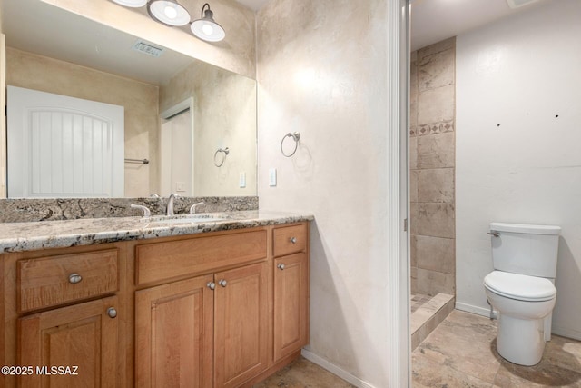 bathroom with visible vents, vanity, baseboards, toilet, and tiled shower