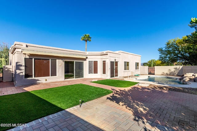 rear view of property with a patio, a fenced backyard, stucco siding, and a yard