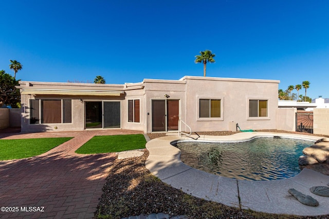 view of front of house with fence, a fenced in pool, stucco siding, and a patio area