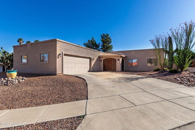 view of front of property featuring an attached garage, stucco siding, and concrete driveway