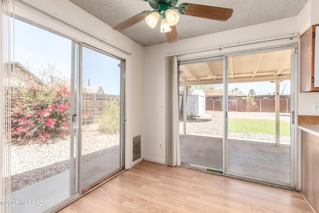 entryway with ceiling fan and light wood-style floors