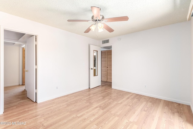 spare room with visible vents, a ceiling fan, baseboards, and light wood-type flooring