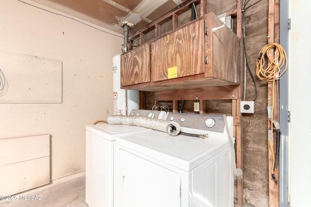 washroom with cabinet space, water heater, and washer and dryer
