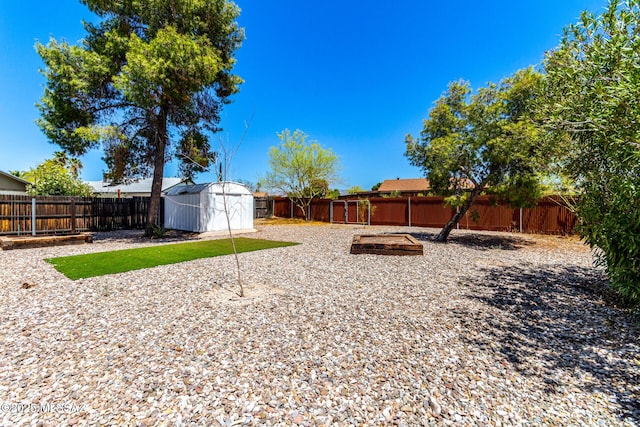 view of yard featuring an outdoor structure, a fenced backyard, and a storage shed