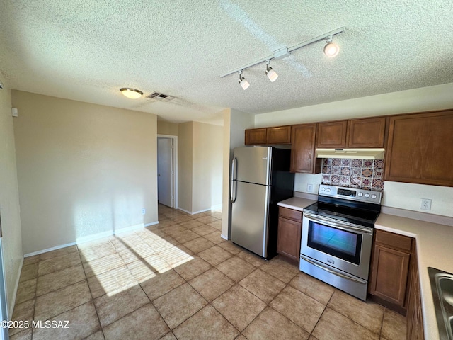 kitchen featuring visible vents, light countertops, track lighting, under cabinet range hood, and stainless steel appliances
