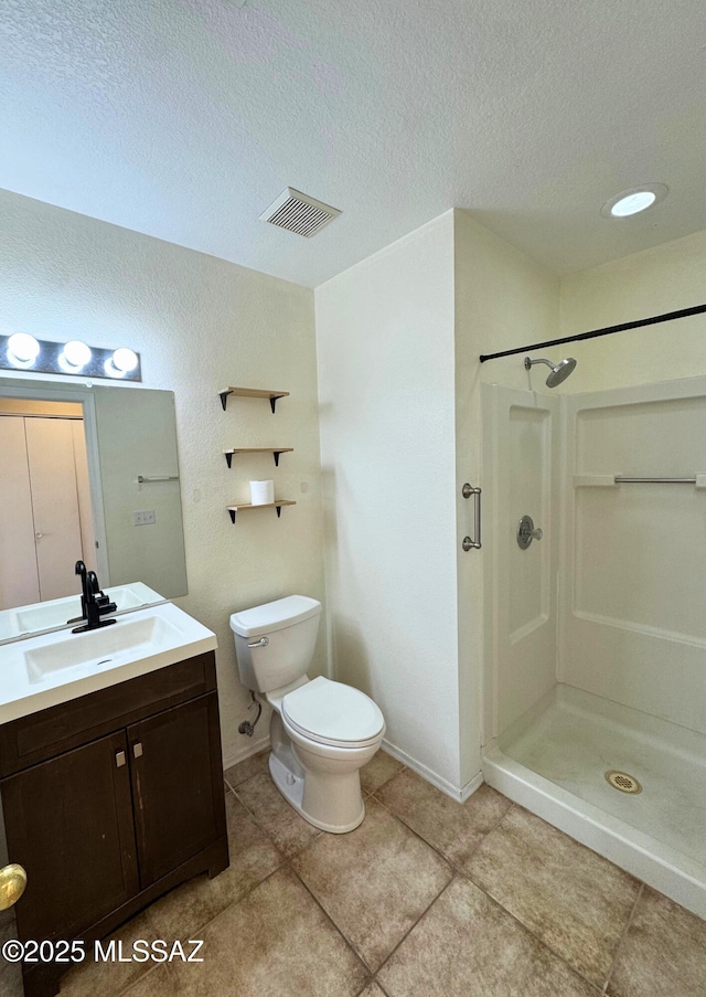 full bathroom featuring toilet, a textured ceiling, walk in shower, and vanity