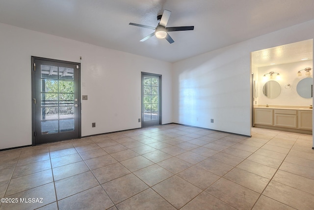 interior space with a ceiling fan, ensuite bathroom, light tile patterned flooring, and access to exterior