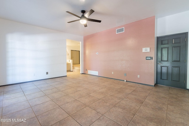 empty room featuring light tile patterned floors, baseboards, a ceiling fan, and visible vents