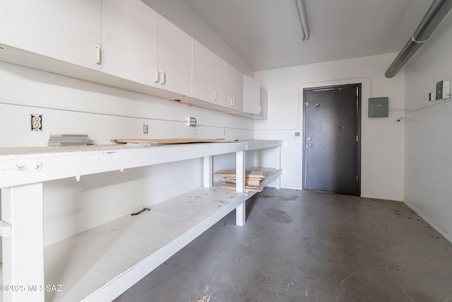 garage with electric panel and baseboards