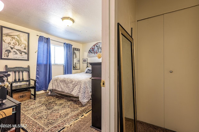 bedroom with a textured ceiling and a closet