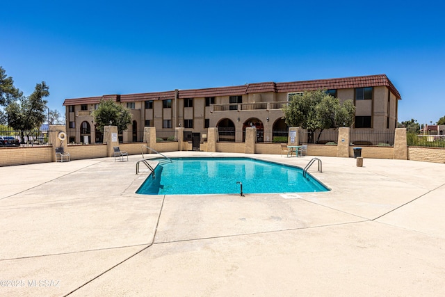 pool featuring a patio area and fence