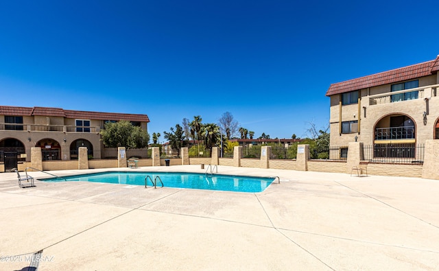 pool featuring a patio area and fence