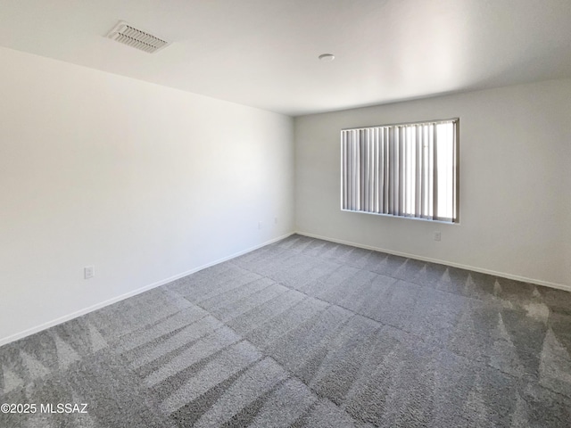 empty room featuring baseboards, carpet flooring, and visible vents