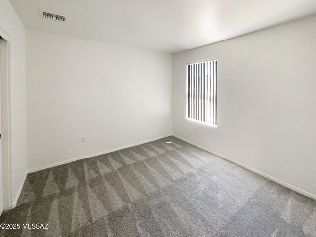carpeted spare room with baseboards and visible vents
