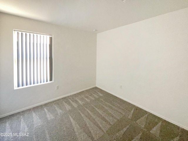 carpeted spare room with baseboards