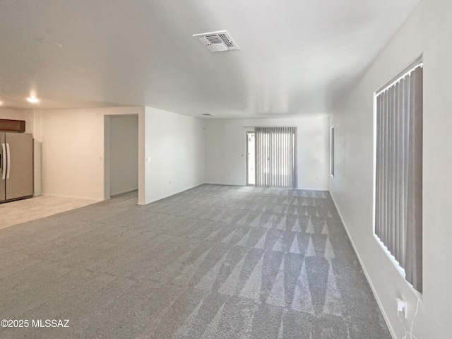 unfurnished living room with visible vents and carpet