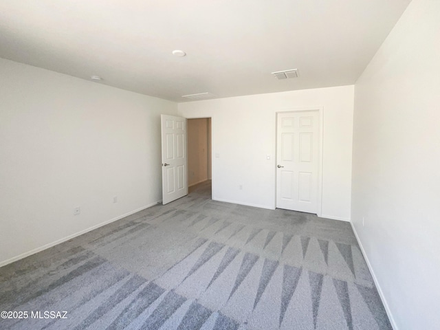 unfurnished bedroom with carpet flooring, baseboards, and visible vents