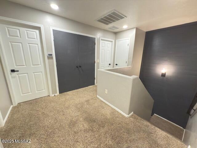 hallway featuring visible vents, recessed lighting, baseboards, and carpet floors