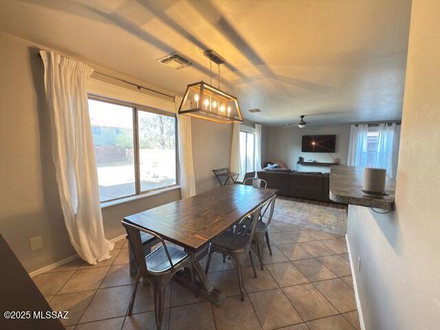 dining area featuring visible vents, ceiling fan with notable chandelier, and tile patterned floors