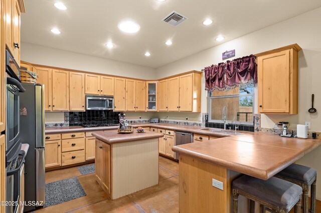 6300 N Abington Rd, Tucson, AZ 85743 - kitchen with stainless steel appliances, light brown cabinetry, a peninsula, a sink, and a breakfast bar area