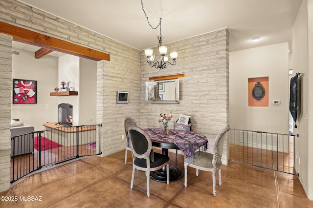 6300 N Abington Rd, Tucson, AZ 85743 - dining room featuring brick wall, a chandelier, concrete floors, and a warm lit fireplace