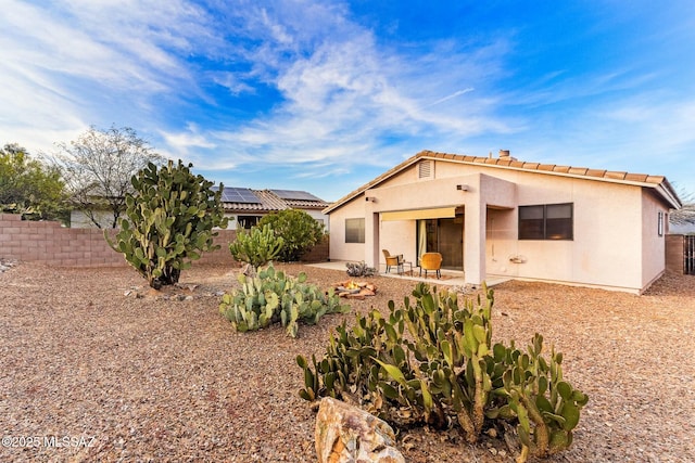 back of property with a tiled roof, fence, a patio area, and stucco siding