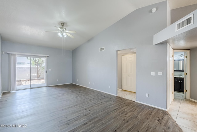 7848 E 35th St, Tucson, AZ 85710 - unfurnished living room featuring a ceiling fan, wood finished floors, baseboards, and high vaulted ceiling