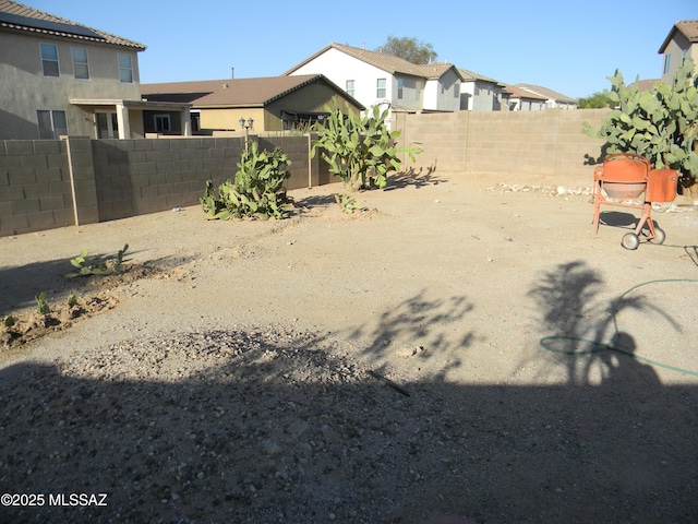 view of yard featuring a fenced backyard and a residential view